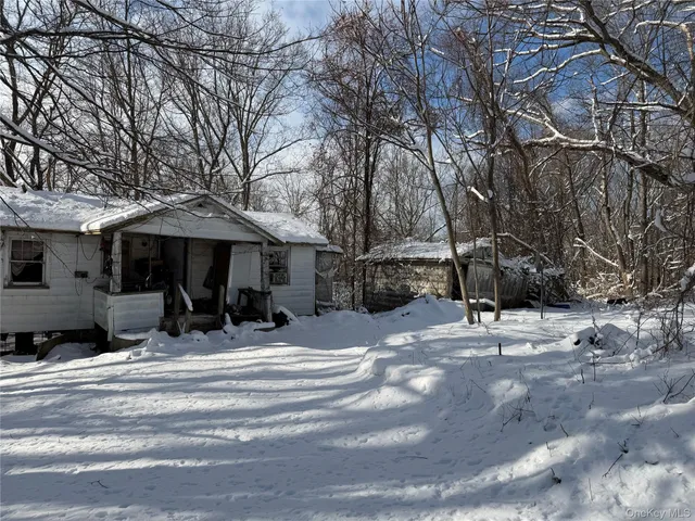 a view of a house with snow on the side of the road