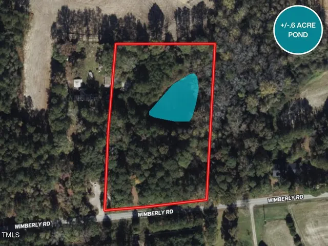 an aerial view of residential houses with outdoor space and trees all around