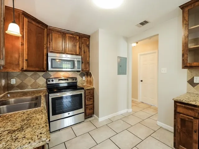 a kitchen with stainless steel appliances granite countertop a stove a microwave and a refrigerator