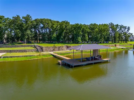 a view of a swimming pool with lawn chairs under an umbrella