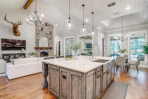 a large white kitchen with a large island in the center