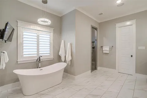 a white bath tub sitting in a bathroom next to a window