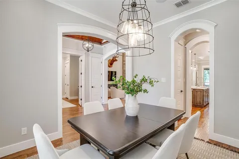 a view of a dining room with furniture wooden floor and chandelier