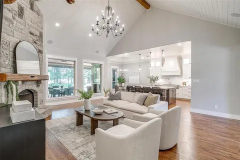 a living room with furniture a fireplace and a chandelier