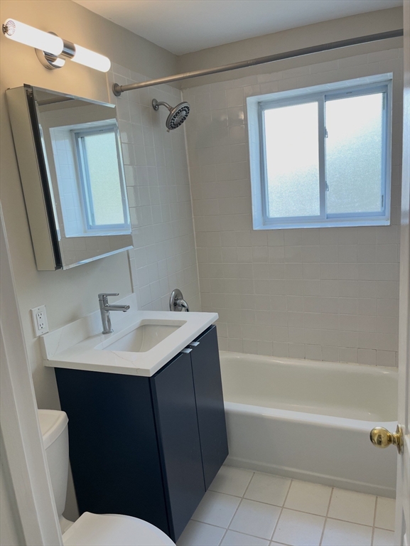 22 Westgate Road, Unit 3 Boston, MA 02467 - Photo 11 of 18 a bathroom with a bathtub sink vanity and mirror
