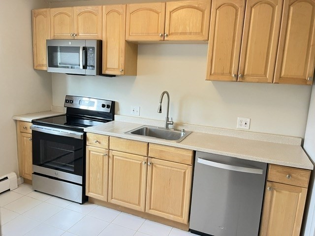 22 Westgate Road, Unit 3 Boston, MA 02467 - Photo 4 of 18 a kitchen with stainless steel appliances granite countertop a sink and a microwave