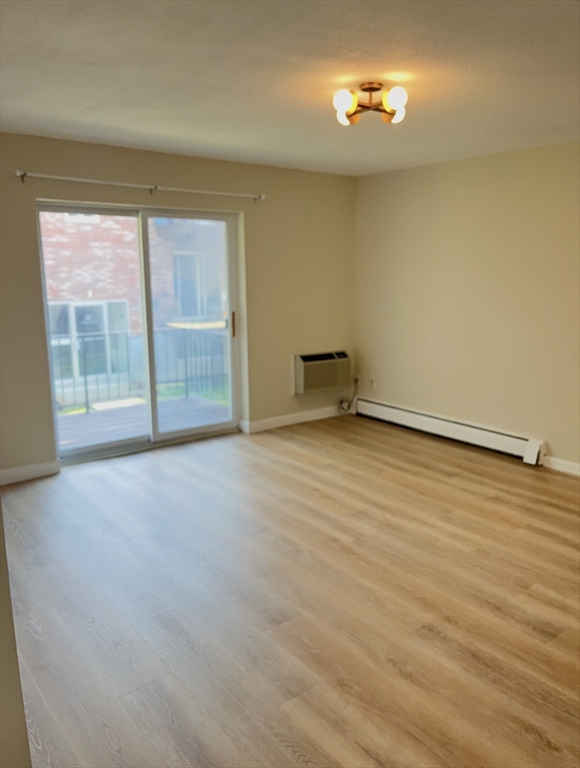 22 Westgate Road, Unit 3 Boston, MA 02467 - Photo 7 of 18 an empty room with wooden floor and windows