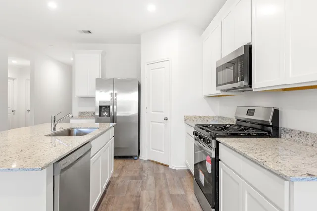 a kitchen with stainless steel appliances granite countertop a sink stove and refrigerator