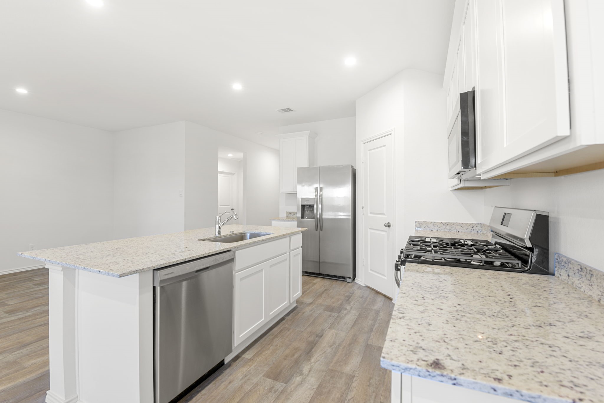 30906 Rockstock Road Fulshear, TX 77441 - Photo 11 of 43 a kitchen with stainless steel appliances granite countertop a stove a sink and a refrigerator