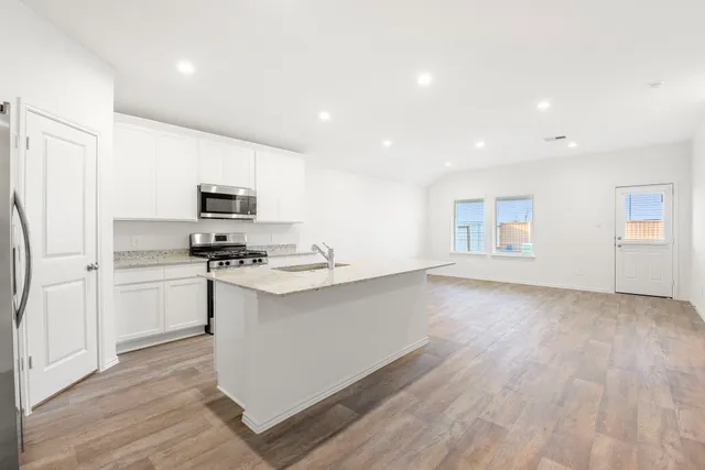 a kitchen with a sink stove and cabinets