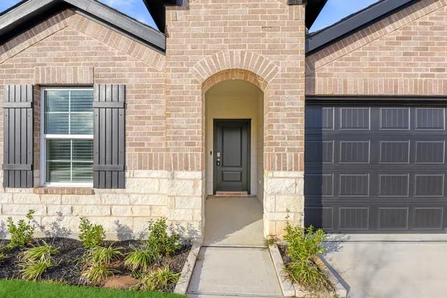 a front view of a house with a garden