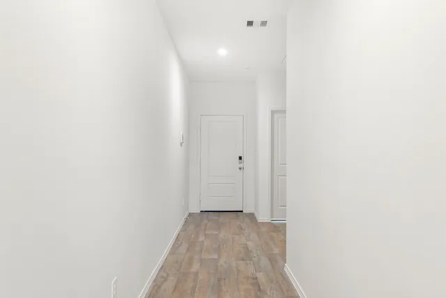 a view of a room with wooden floor and a bathroom