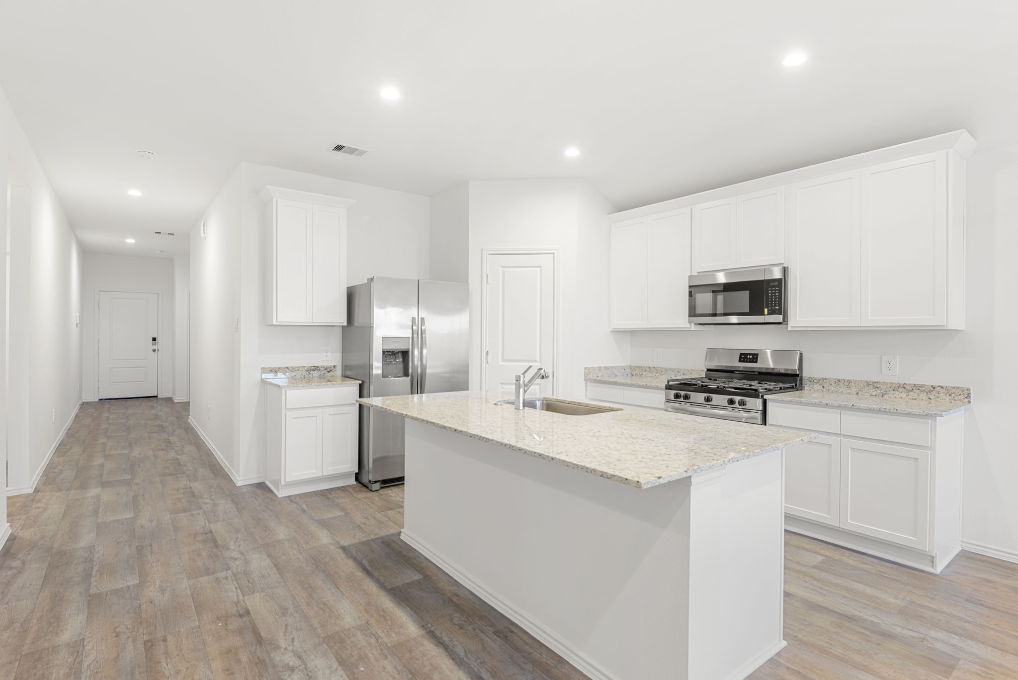 30906 Rockstock Road Fulshear, TX 77441 - Photo 9 of 43 a kitchen with white cabinets and stainless steel appliances