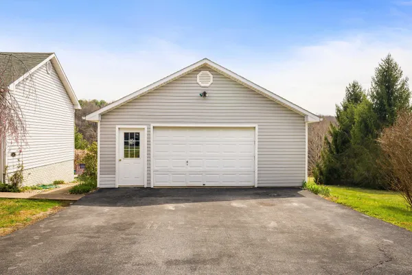 a view of a white house with a yard and garage