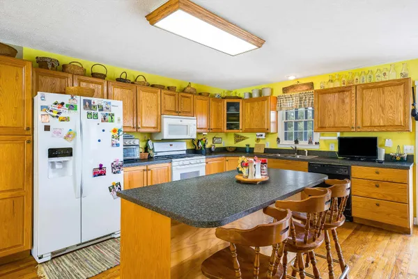 a kitchen with stainless steel appliances kitchen island granite countertop a sink and cabinets