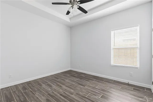 an empty room with a window and ceiling fan