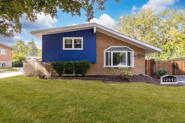 a view of a house with a yard and sitting area