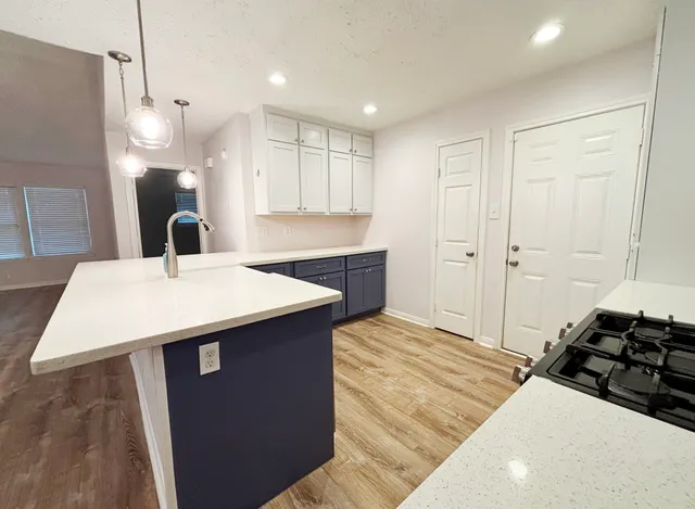 a kitchen with stainless steel appliances a sink a stove a refrigerator and cabinets