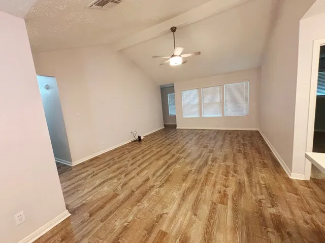 wooden floor in an empty room with a window