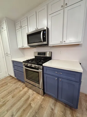 a kitchen with stainless steel appliances granite countertop a stove a microwave and cabinets