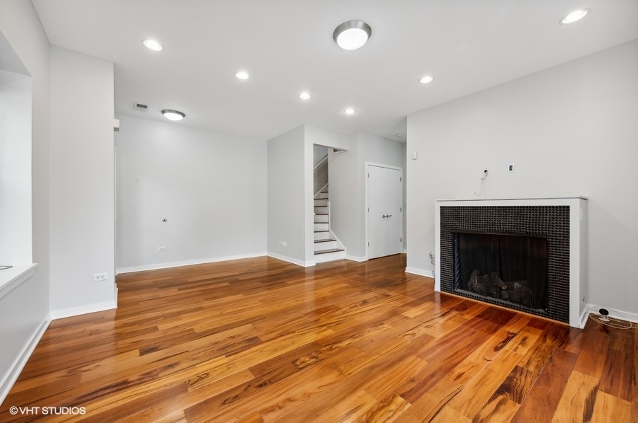 1231 West Arthington Street Chicago, IL 60607 - Photo 15 of 34 a view of an empty room with wooden floor fireplace and a window