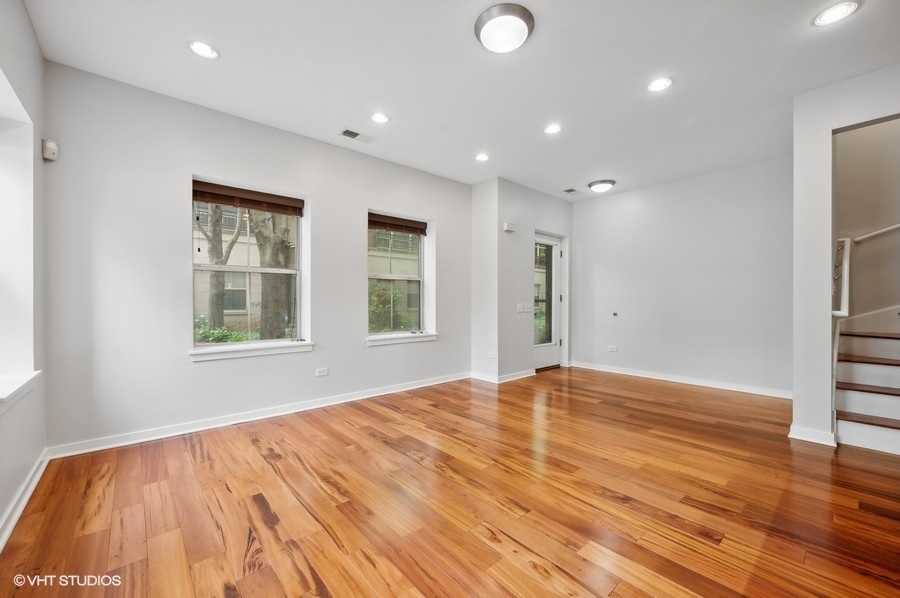 1231 West Arthington Street Chicago, IL 60607 - Photo 16 of 34 a view of an empty room with wooden floor and a window