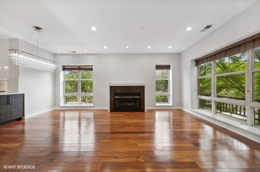 1231 West Arthington Street Chicago, IL 60607 - Photo 3 of 34 a view of empty room with wooden floor and fireplace