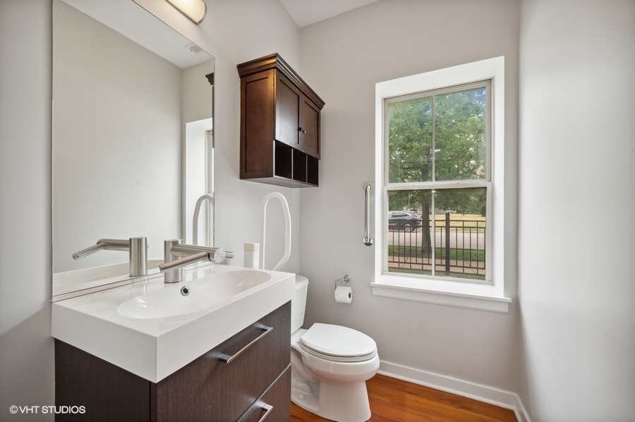 1231 West Arthington Street Chicago, IL 60607 - Photo 31 of 34 a bathroom with a sink toilet a mirror and window