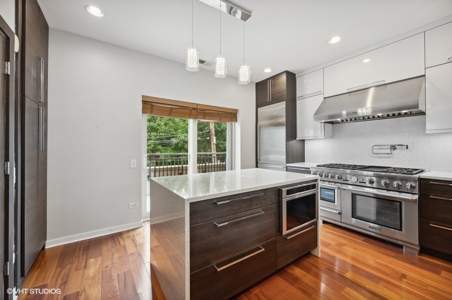 1231 West Arthington Street Chicago, IL 60607 - Photo 10 of 34 a kitchen with stainless steel appliances granite countertop a stove a sink and a refrigerator