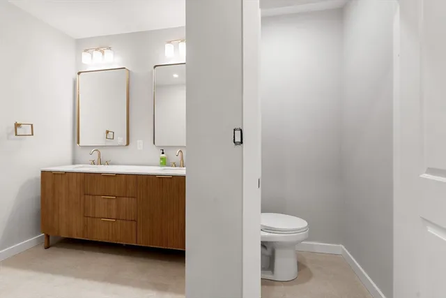 a bathroom with a toilet a sink and mirror