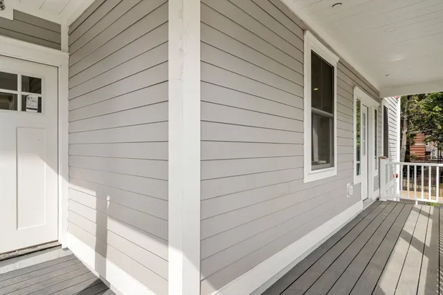 a view of a balcony with wooden floor and floor to ceiling window