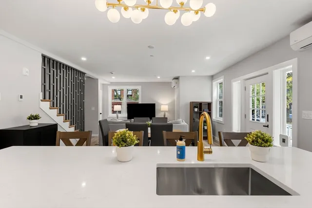 a living room with furniture a flat screen tv and a large window