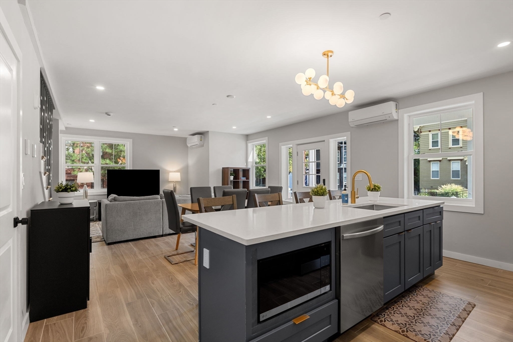 59 Perrin Street, Unit 1 Boston, MA 02119 - Photo 4 of 33 a large white kitchen with a large island in the center