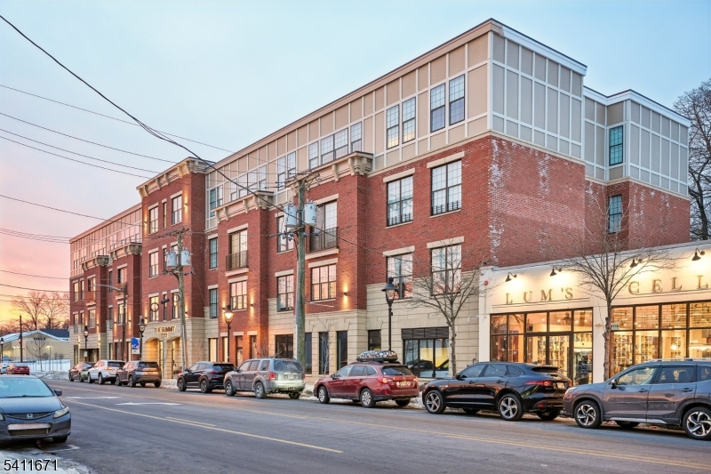 a city street lined with parked cars front of buildings