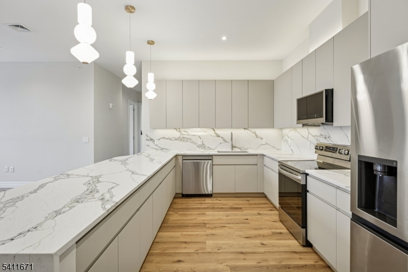 1722 Springfield Avenue, Unit 402 Maplewood, NJ 07040 - Photo 12 of 34 a kitchen with granite countertop a sink stove and refrigerator