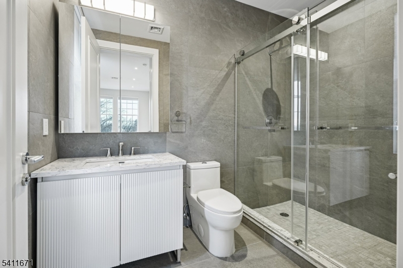 1722 Springfield Avenue, Unit 402 Maplewood, NJ 07040 - Photo 13 of 34 a bathroom with a shower sink vanity and toilet