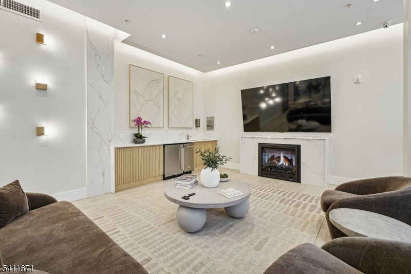 1722 Springfield Avenue, Unit 402 Maplewood, NJ 07040 - Photo 20 of 34 a living room with furniture a fireplace and a flat screen tv