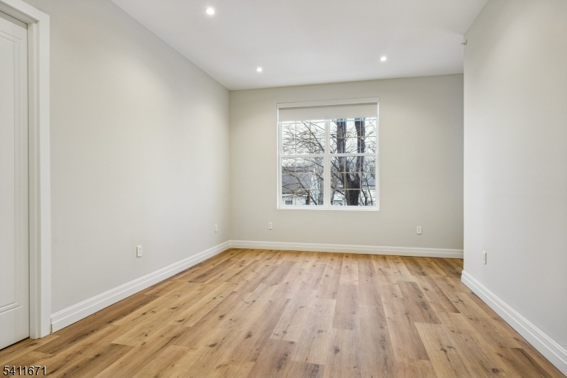 1722 Springfield Avenue, Unit 402 Maplewood, NJ 07040 - Photo 26 of 34 an empty room with wooden floor and windows