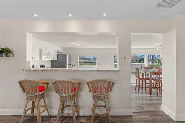 a kitchen with a dining table chairs and white cabinets