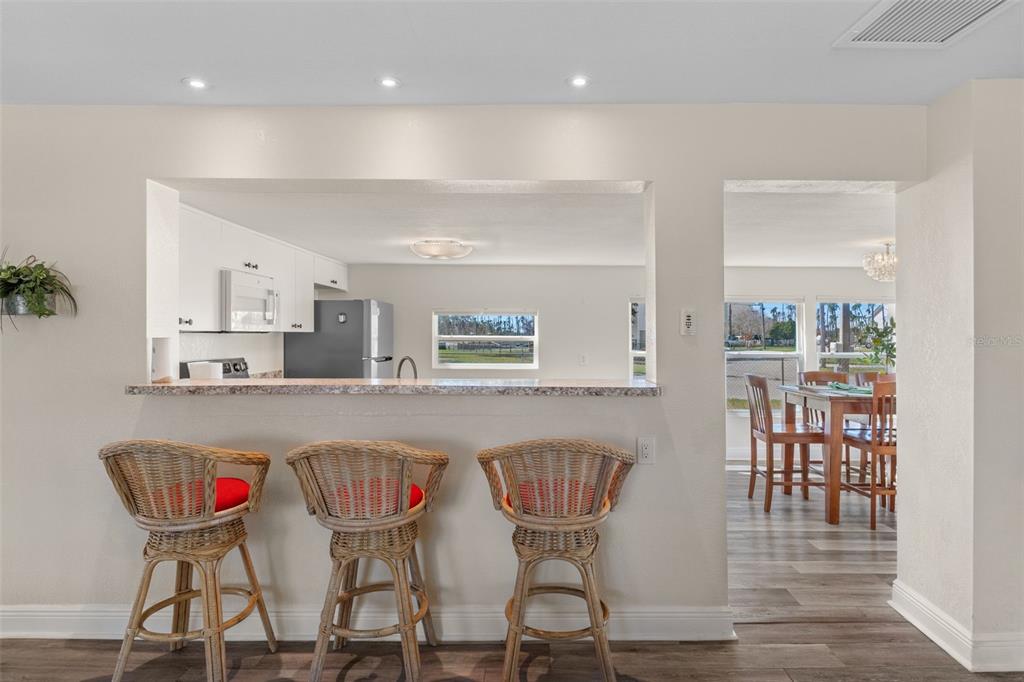 7272 Westwind Street Weeki Wachee, FL 34607 - Photo 13 of 33 a kitchen with a dining table chairs and white cabinets