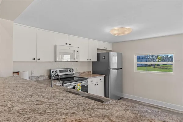 a kitchen with stainless steel appliances granite countertop a refrigerator sink and stove