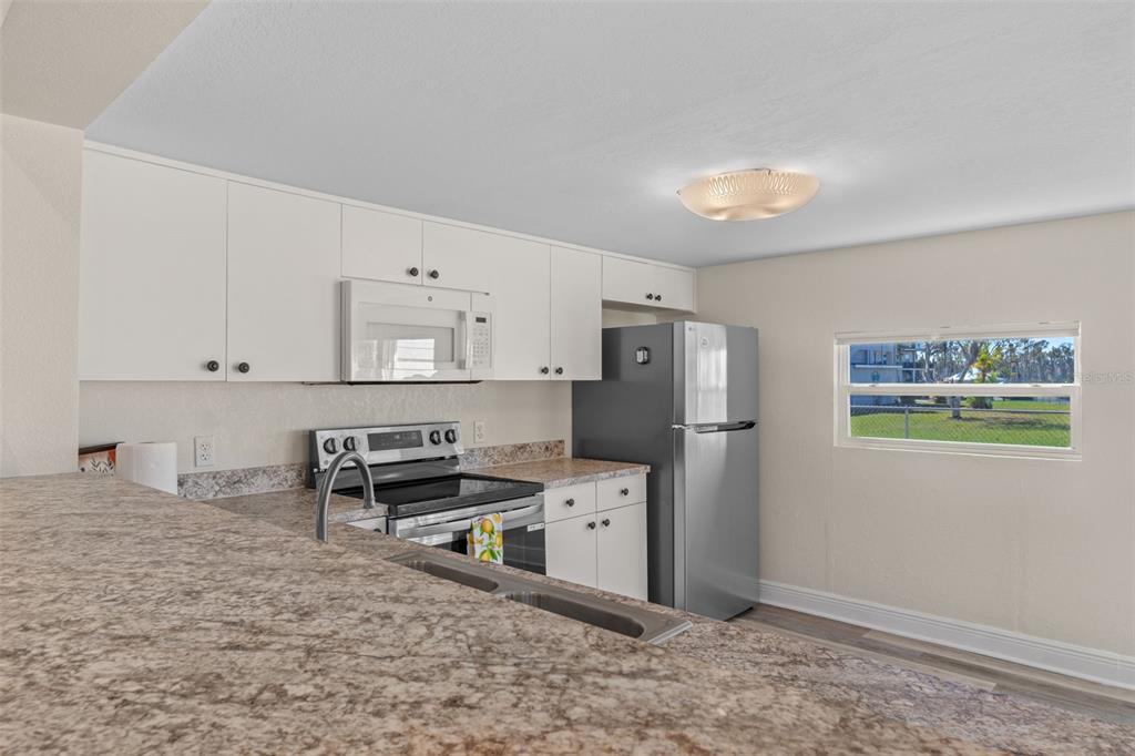 7272 Westwind Street Weeki Wachee, FL 34607 - Photo 14 of 33 a kitchen with stainless steel appliances granite countertop a refrigerator sink and stove