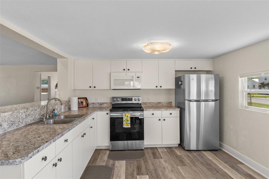 7272 Westwind Street Weeki Wachee, FL 34607 - Photo 15 of 33 a kitchen with stainless steel appliances granite countertop a refrigerator stove and sink