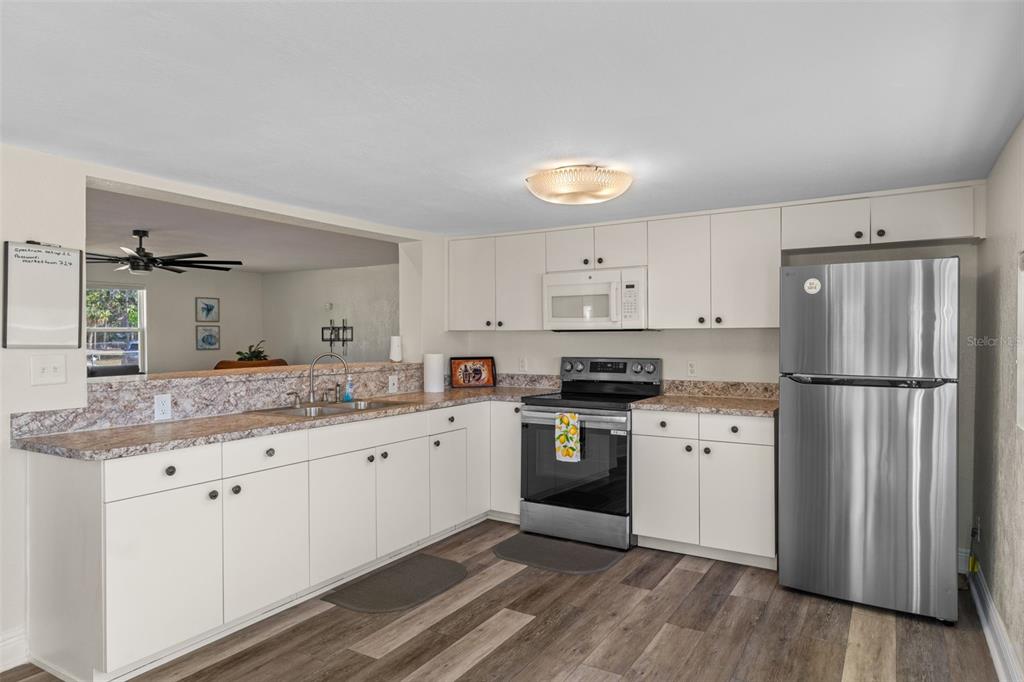 7272 Westwind Street Weeki Wachee, FL 34607 - Photo 16 of 33 a kitchen with granite countertop a refrigerator stove top oven and sink