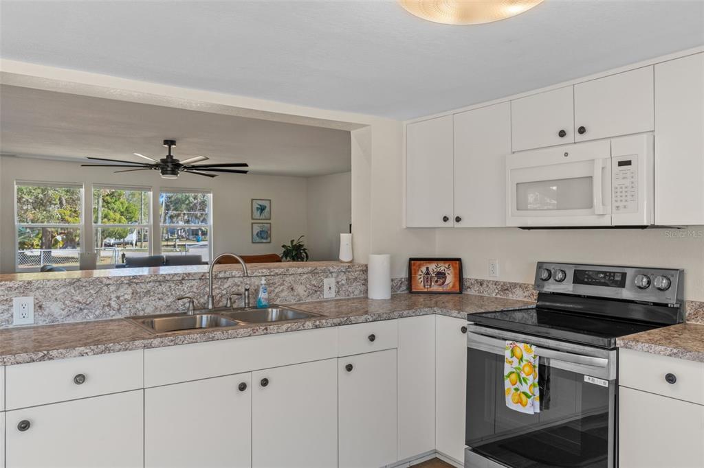 7272 Westwind Street Weeki Wachee, FL 34607 - Photo 17 of 33 a kitchen with stainless steel appliances granite countertop a sink and a stove