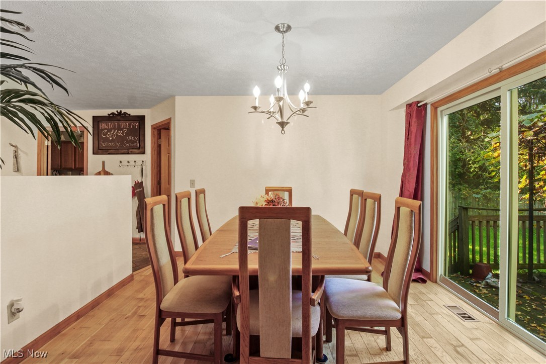 2632 Berry Road Akron, OH 44320 - Photo 11 of 39 Dining room featuring a textured ceiling, a chandelier, and light hardwood / wood-style floors