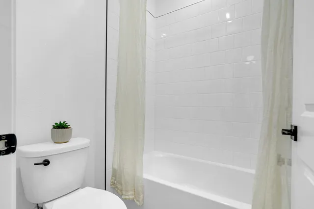 a white toilet sitting next to a bath tub