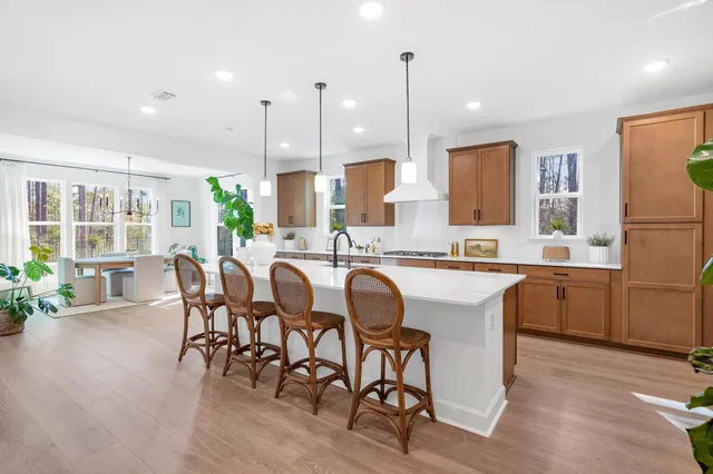 a kitchen with kitchen island granite countertop a table chairs sink and wooden floor