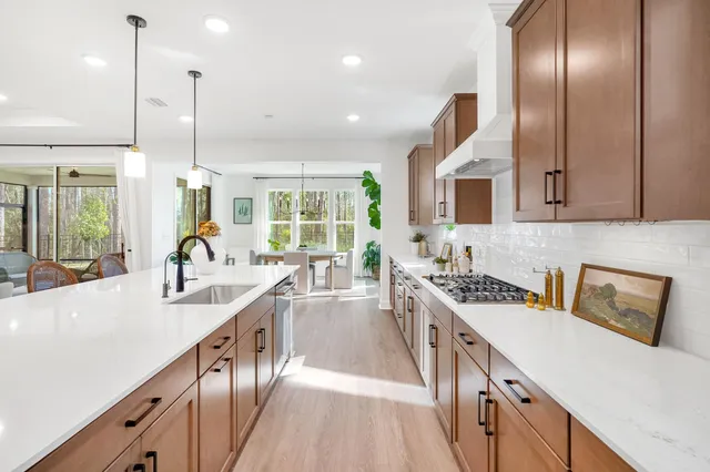 a kitchen with stainless steel appliances granite countertop a sink a stove and a wooden floors