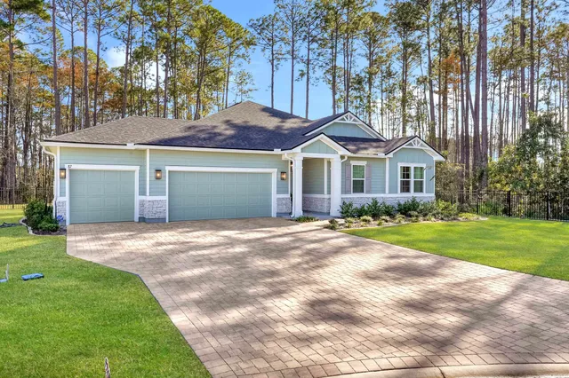 a front view of a house with a garden and trees